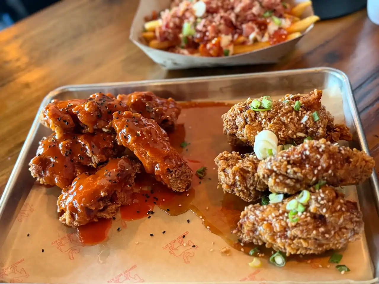Two flavors of Korean wings with bacon kimchi loaded fries